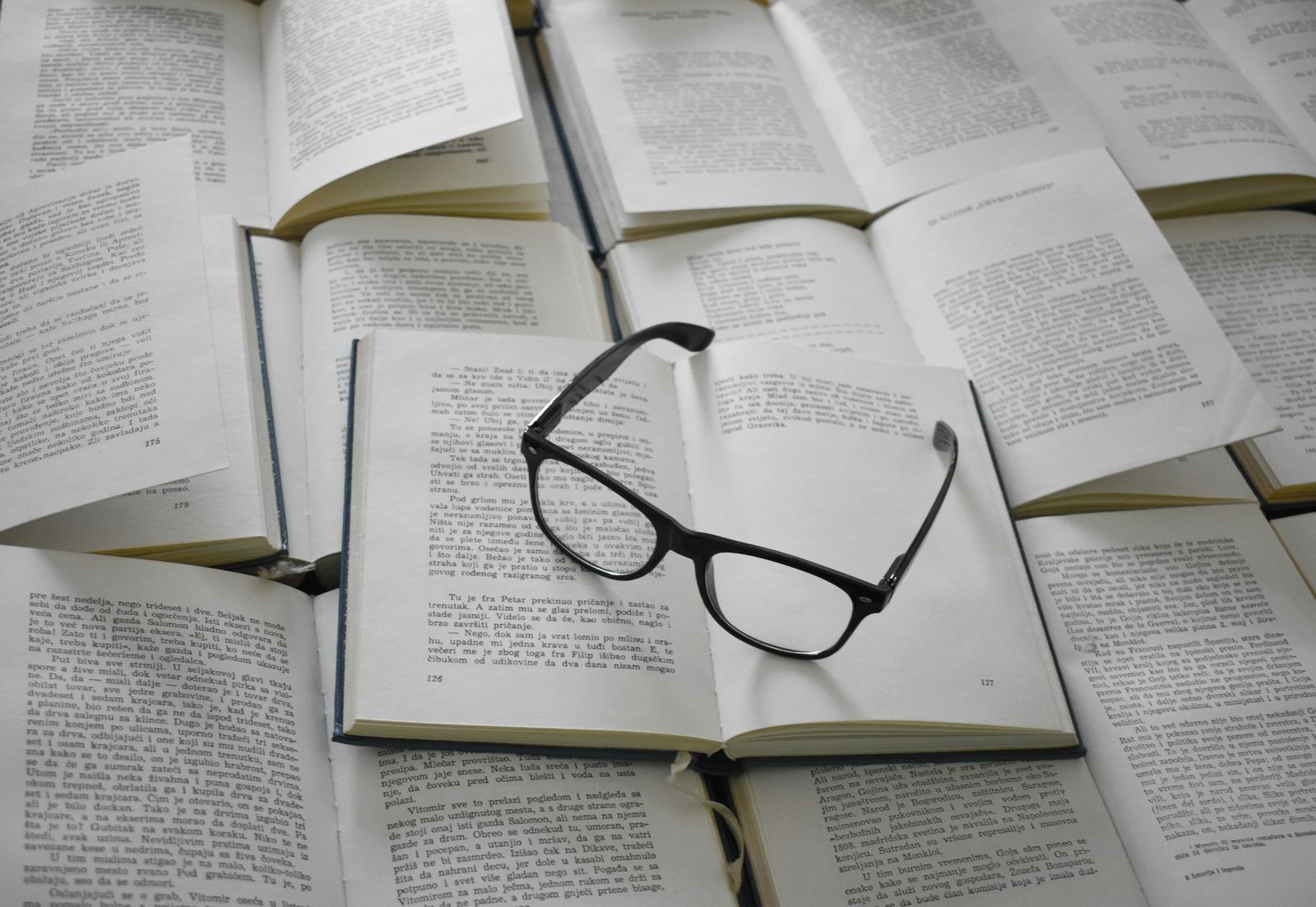 A pair of glasses resting on open books.